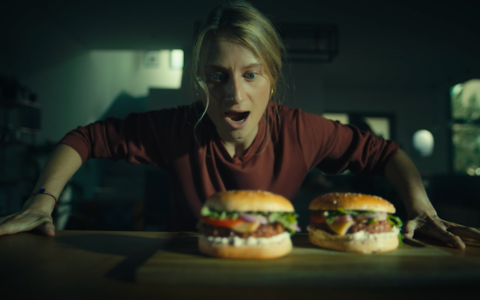 Image extraite du film Révélez votre instinct végétal Accro réalisée par Fantastic, où le personnage bondit au dessus de la table prêt à dévorer ses burgers